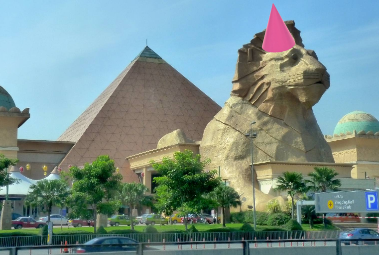 Singa Sunway Pyramid sedang memakai topi parti berwarna pink